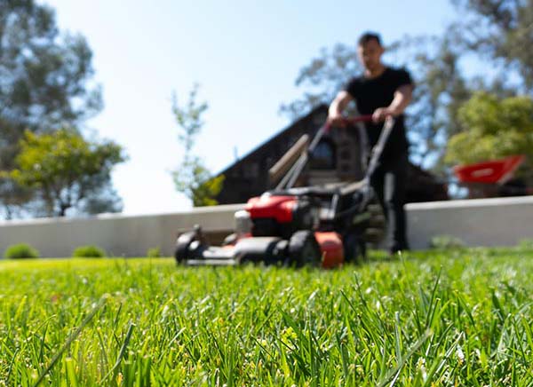 landscape maintenance worker mowing lawn